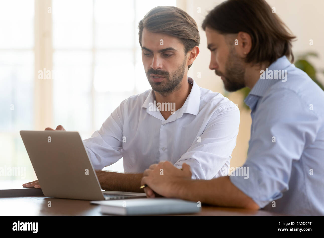 Konzentrierte Geschäftsmann Verkäufer männlichen Klienten zeigen, Präsentation auf dem Laptop consult Stockfoto