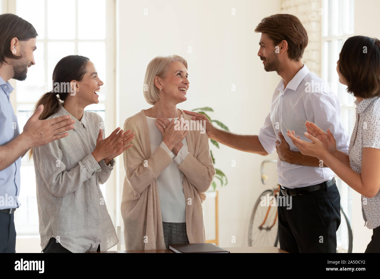 Gerne alten weiblichen Mitarbeiter erhalten durch Chef und Team geschätzt Stockfoto
