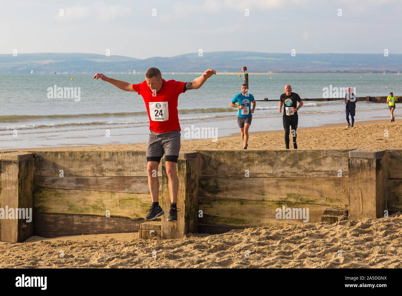 Bournemouth, Dorset, Großbritannien. 20. Oktober 2019. Die Teilnehmer nehmen an den Strand Rennen, rennen die Gezeiten, Ebbe Strand entlang der wunderschönen Küste von Bournemouth Strand in Richtung Sandbänke Strand laufen. Läufer laufen die 5k- oder 10k Rennen an der Küste entlang und über die buhnen, bevor die Flut kommt. Eine trockene kühle am frühen Morgen mit etwas Sonnenschein. Credit: Carolyn Jenkins/Alamy leben Nachrichten Stockfoto