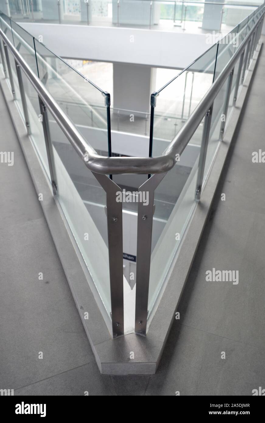 Vertikale Aufnahme von Glasoberflächen, die einen scharfen Winkel bilden Ein modernes Gebäude Stockfoto