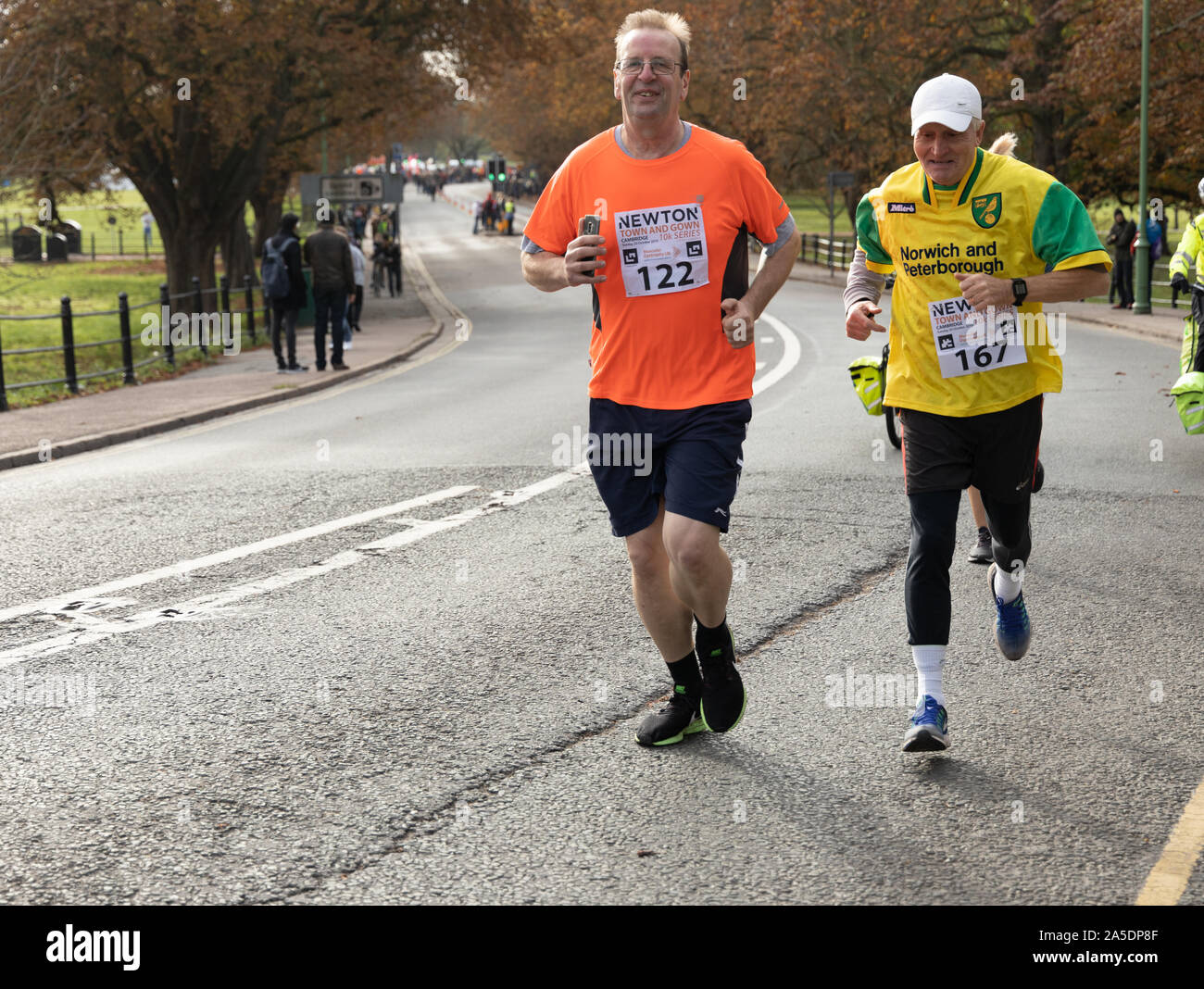 Zwei ältere männliche Läufer in der Cambridge Stadt und Kleid 10 k laufen, Oktober 2019 über landschaftliche Sehenswürdigkeiten, historischen University College Gebäude und entlang der Steuerkurve Stockfoto