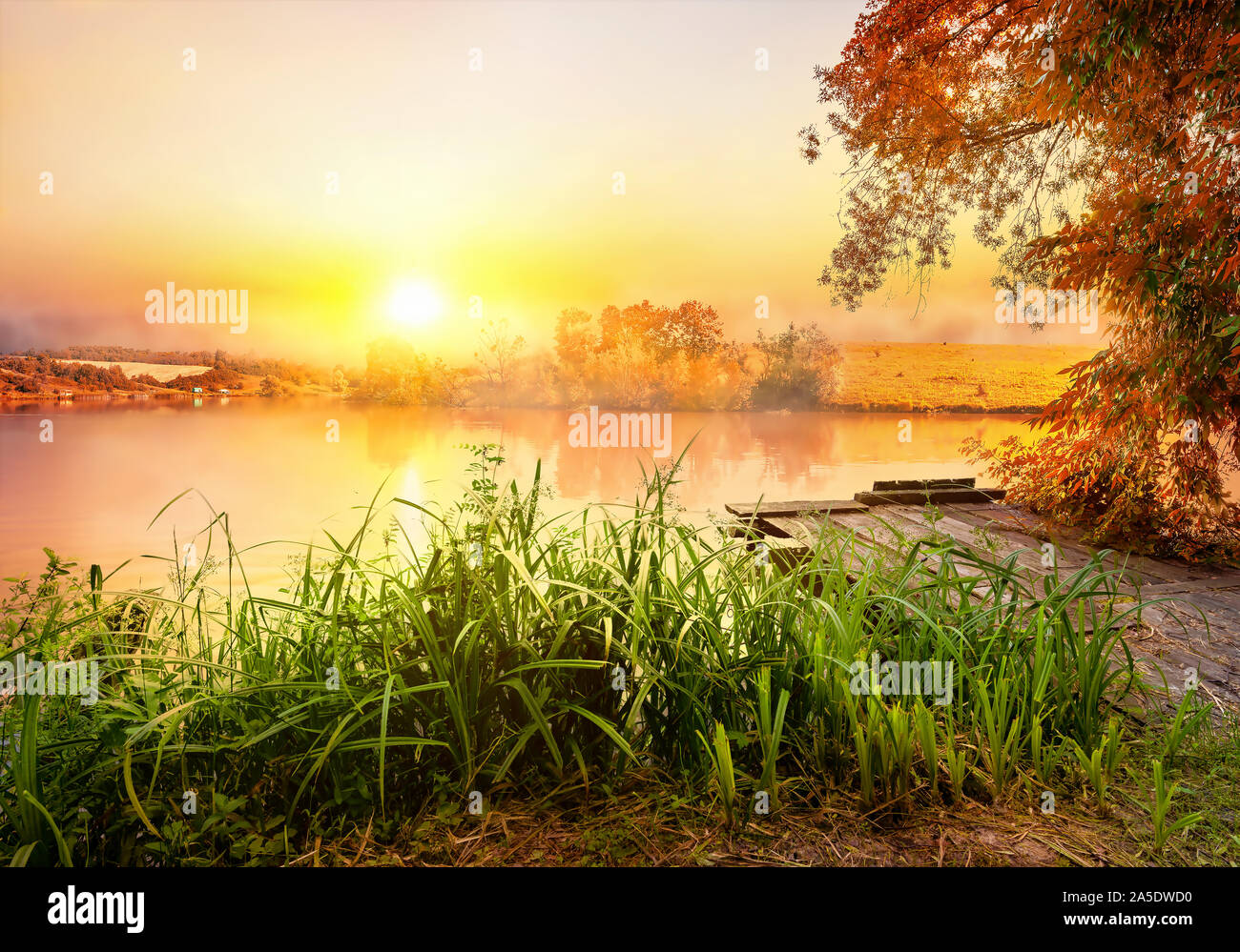 Angelausrüstung auf hölzernen Pier und ruhigen Fluss am Morgen Stockfoto