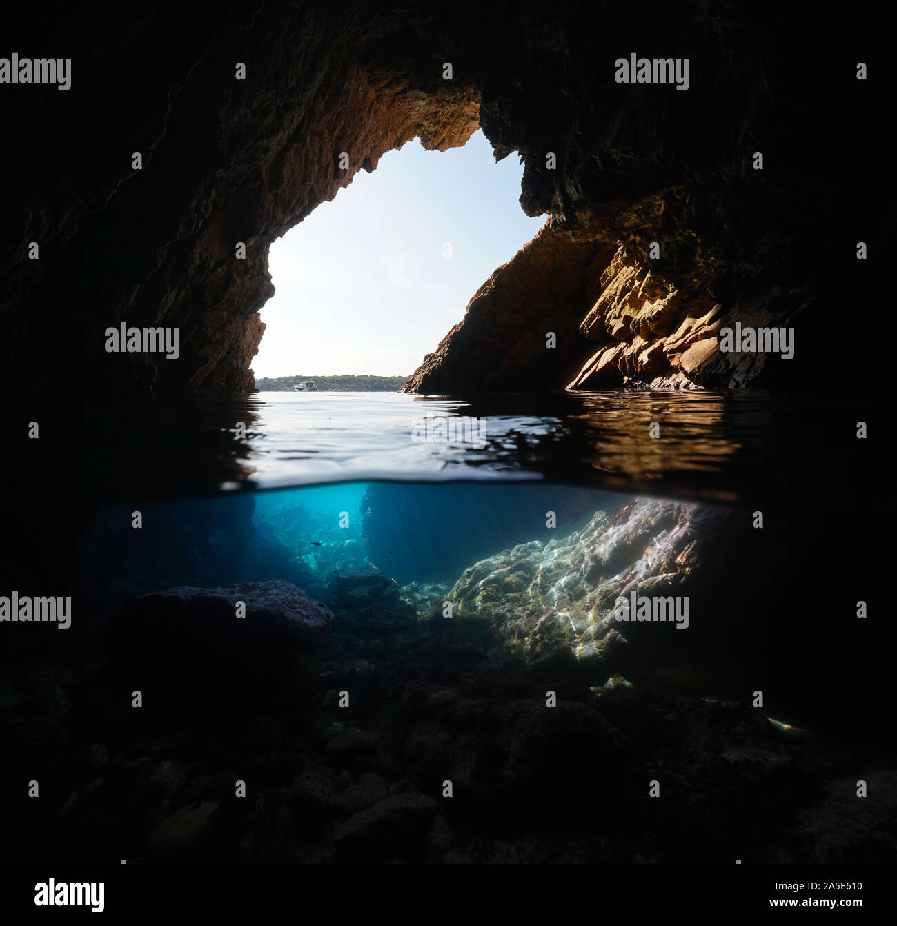 In eine Wasserhöhle, die an der Küste, geteilte Ansicht über und unter Wasser, Mittelmeer, Spanien, Costa Brava, Katalonien, Palamos Stockfoto
