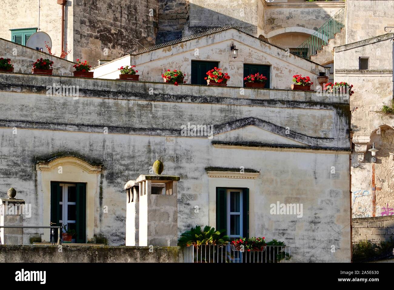 Eingemachte rote Geranien aufgereiht auf einer Terrasse, Matera, Basilikata, Italien Stockfoto