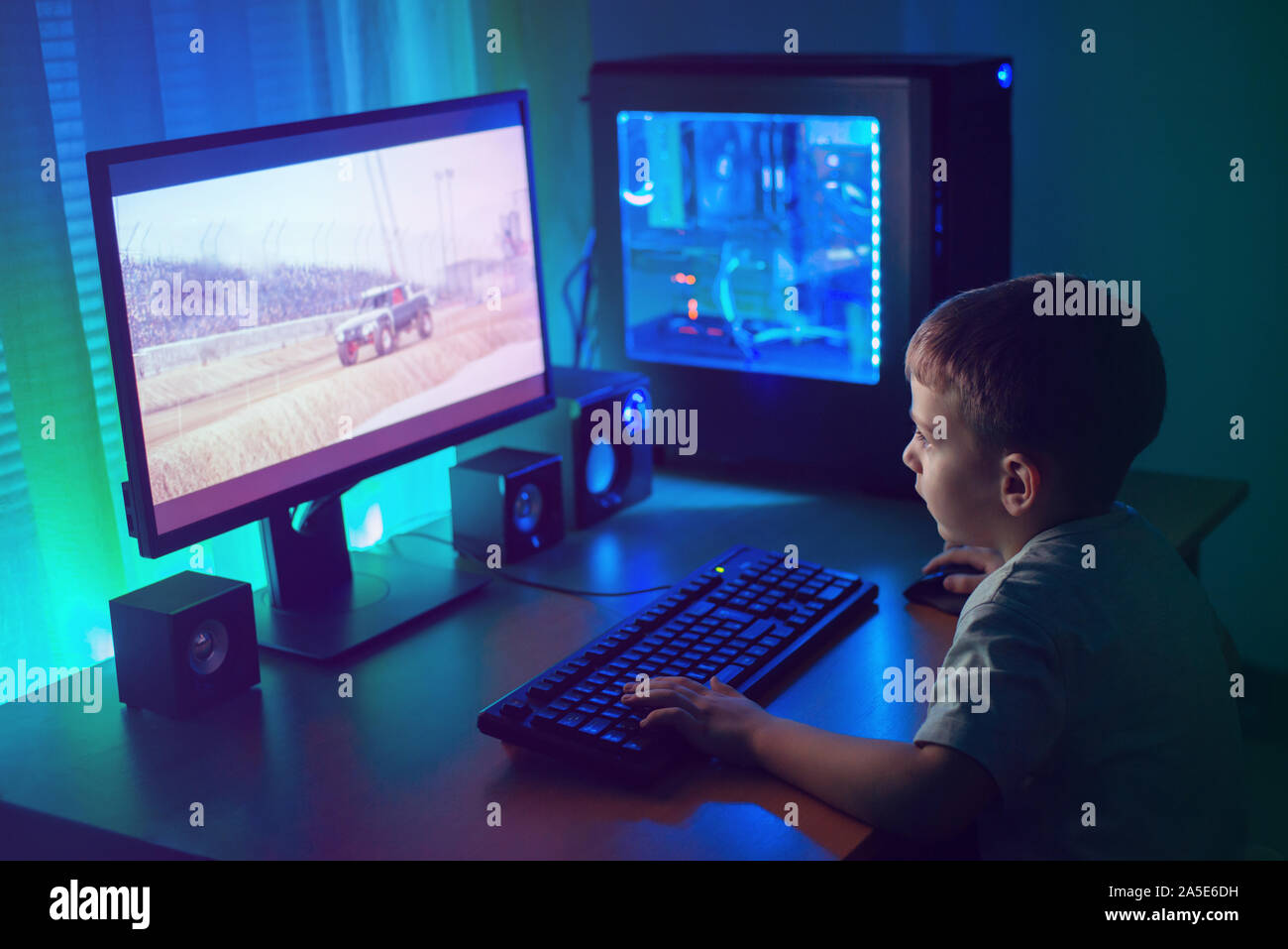 Junge Gamer spielen Sie online mit Freunden. Dunkle Szene mit Gaming-PC und viele RGB-Licht. Stockfoto