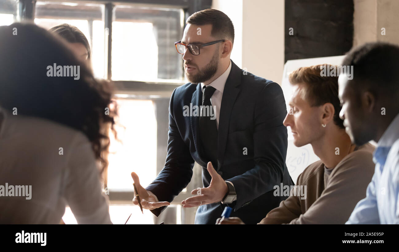 Ernsthafte Geschäftsmann Mentor sprechen mit verschiedenen Leuten in der Gruppe Training Stockfoto
