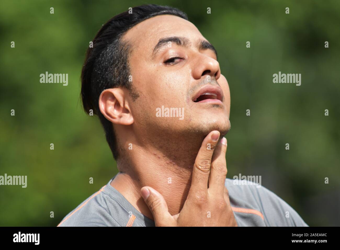 Ein athletischer Mann mit Halsschmerzen Stockfoto