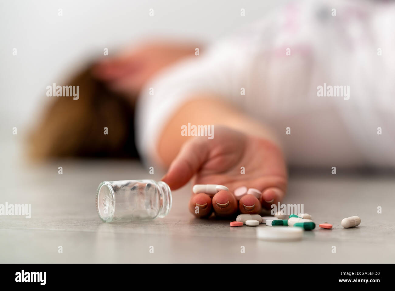 Einnahme von Medizin Überdosierung und lag auf dem Boden mit Pillen Stockfoto