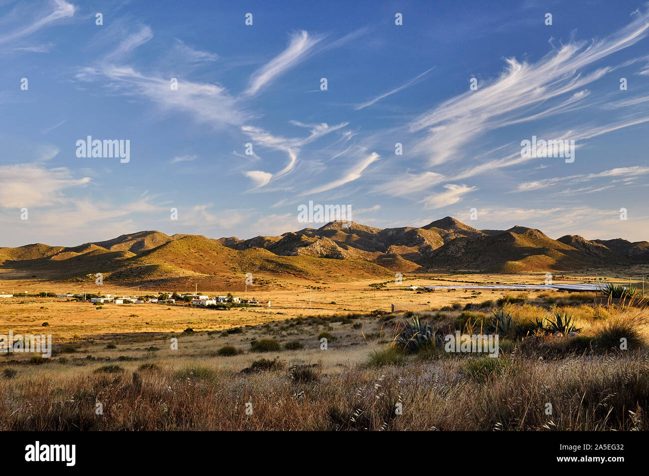Sonnenuntergangslandschaft der Stadt Boca de los Frailes und nahe gelegene Gewächshäuser und Hügel im Naturpark Cabo de Gata-Níjar (Boca de los Frailes, Almeria, Spanien) Stockfoto