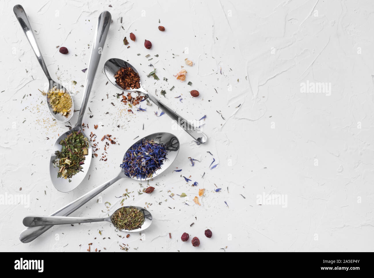 Vielzahl von getrockneten Tee, getrocknete Kräuter, Grün und Früchte Tee auf Löffel über weißen Hintergrund mit kopieren. Stockfoto