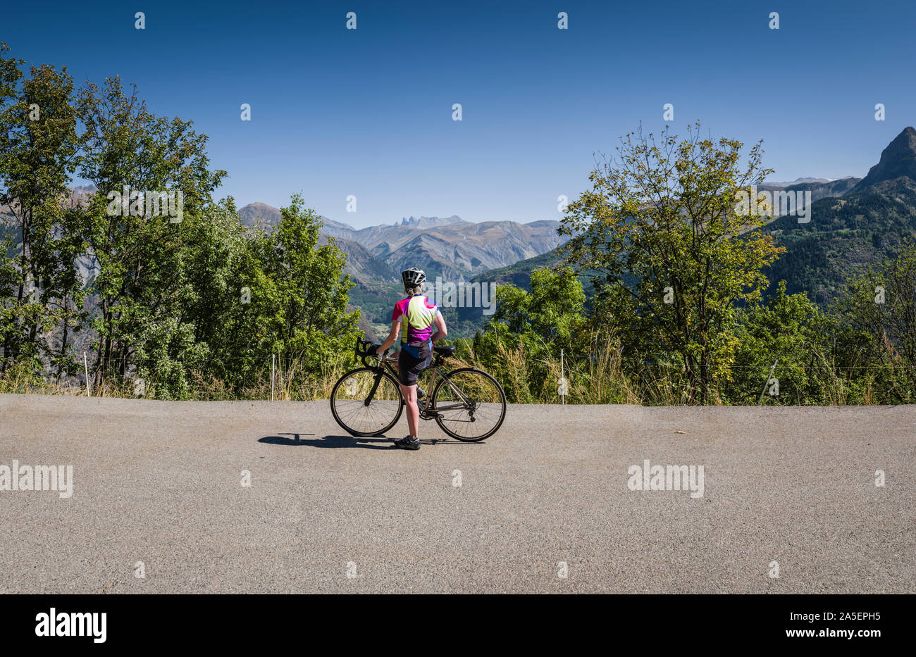 Reife weibliche Radfahrer, die in der Aussicht, Oisans, Französischen Alpen. Stockfoto