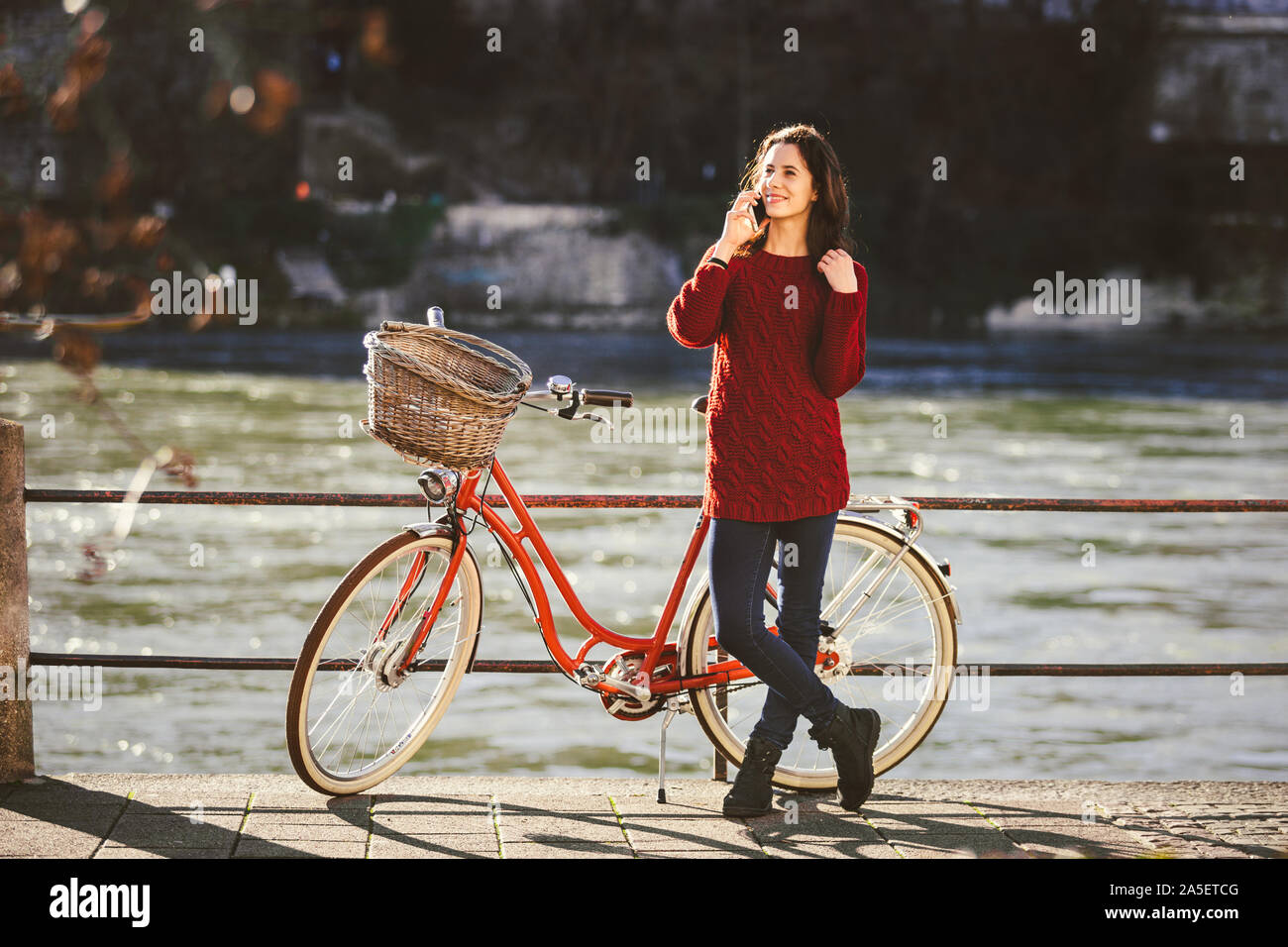 Eine junge weibliche Reisende genießen steht neben einem Fahrradverleih in  der Nähe von einem Fluss in der Stadt Basel. Reisen in der Schweiz. Junge  kaukasier Frau sprechen Stockfotografie - Alamy