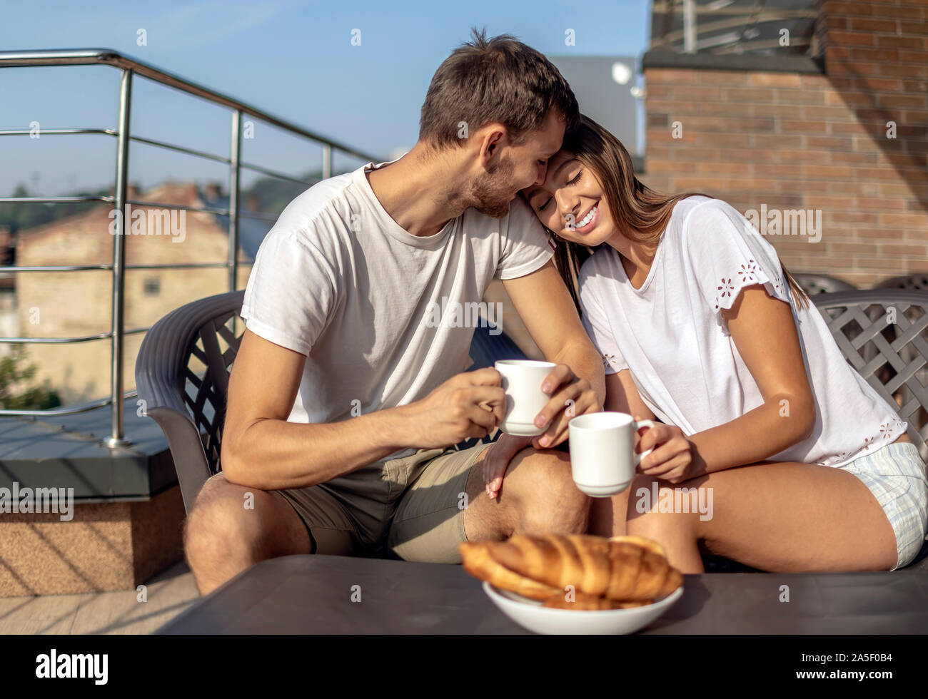 Die jungen Eheleute schwelgte in Ihrer gemütlichen Morgen Frühstück im Freien Stockfoto
