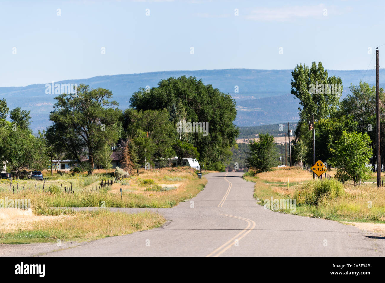 Leere Straße Landstraße 145 durch die kleine Stadt von Redvale, Colorado mit niemand auf Sommer sonnigen Tag mit Sky und Bergblick Stockfoto