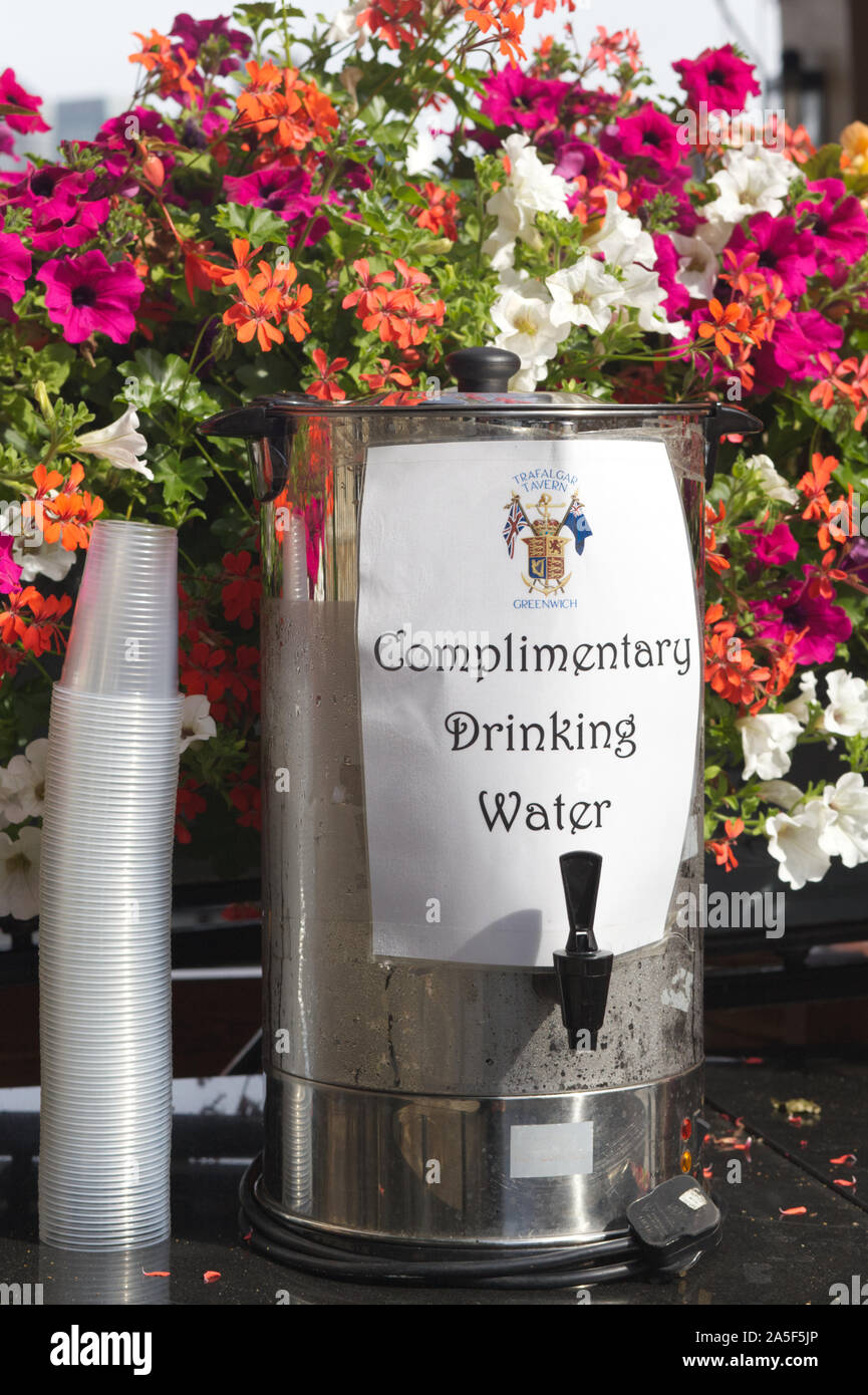Kostenloses Trinkwasser Behälter und Plastikbecher Stockfoto