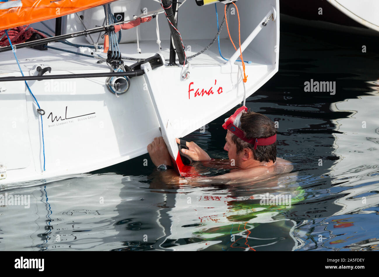 Sailor Inspektion seiner 650 Klasse Racing Yacht nach der ersten Etappe der Transatlantischen Minitransat Rennen Stockfoto