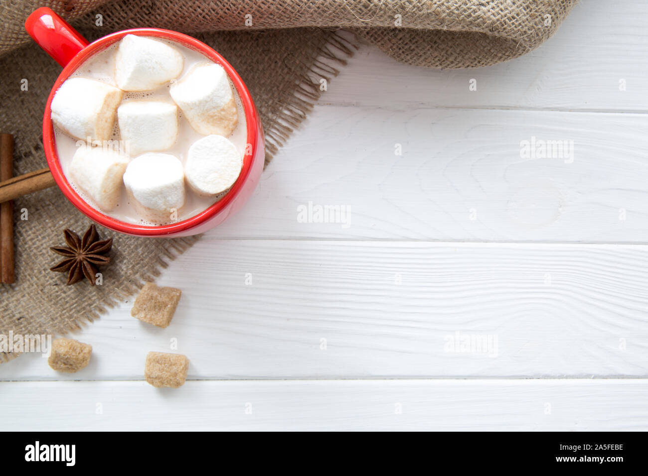 Eine rote Tasse heißen Kakao mit Marshmallows auf weißem Holz- Tabelle, Ansicht von oben, Platz für Text. Ansicht von oben. Stockfoto