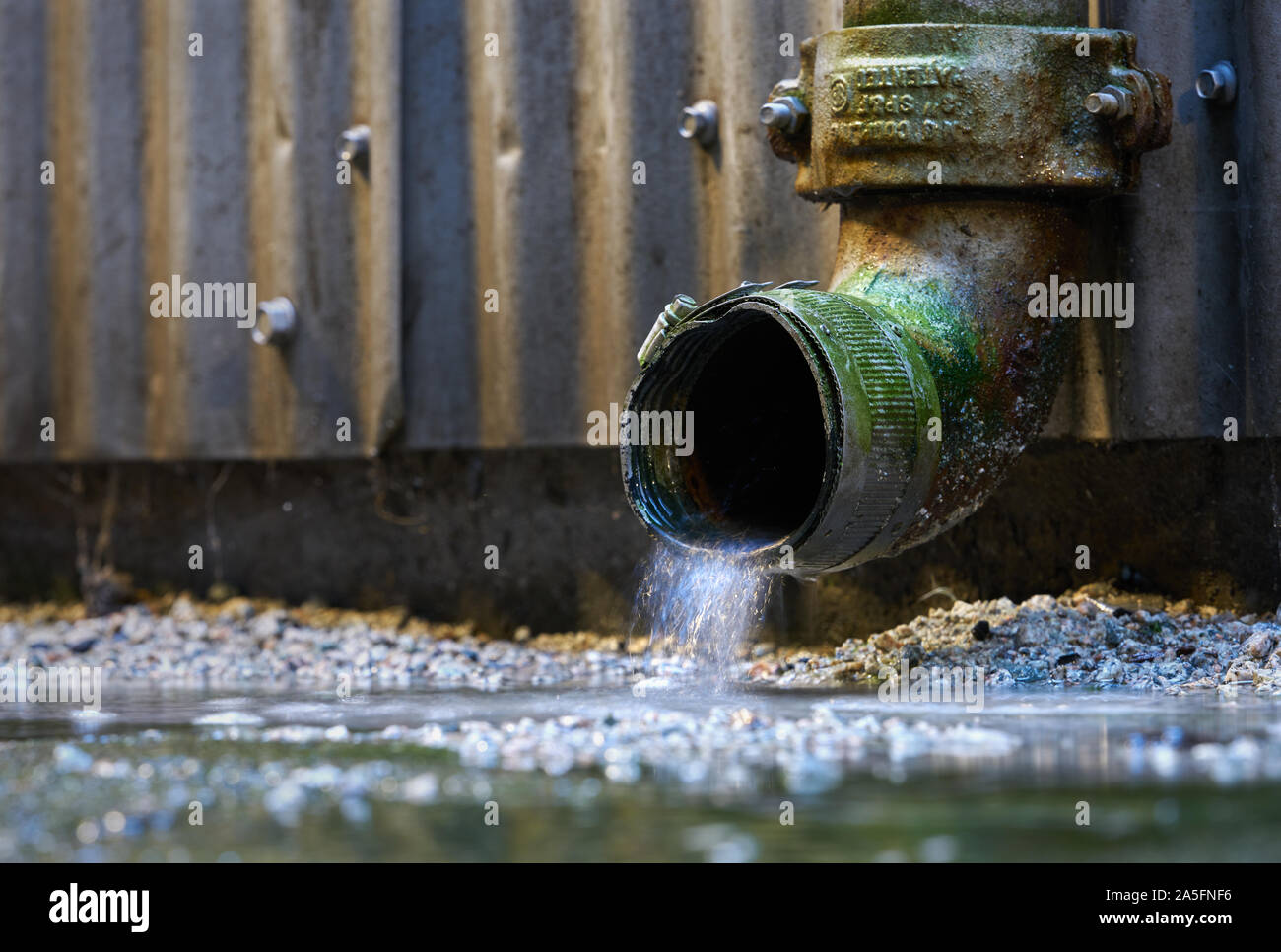 Regenwasser Abflußrohr. Regenwasser aus einem Abflußrohr auf der Seite eines Gebäudes. Stockfoto