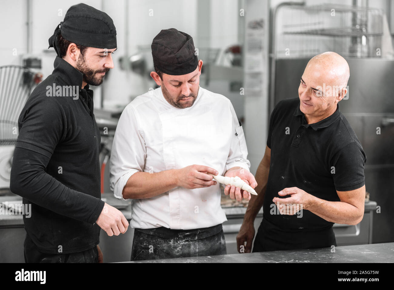 Team der Konditoren, einem Croissant und Sprechen über die Rezeptur. Stockfoto