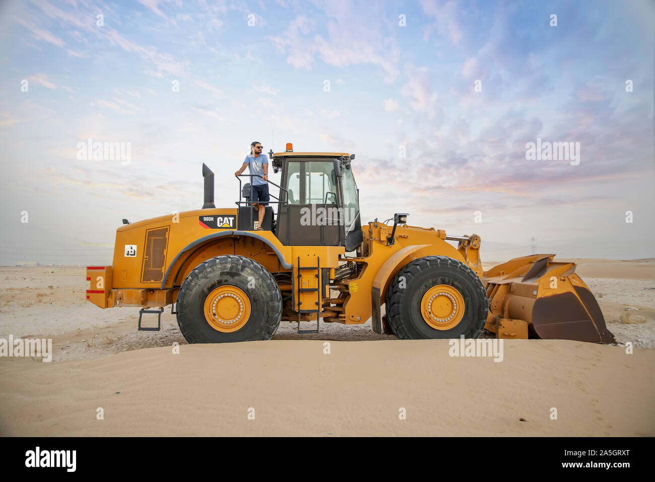 Baustelle eines Industriegebäudes, Minibulldozer ebnet und bewegt Boden während des Autobahnbaus Stockfoto