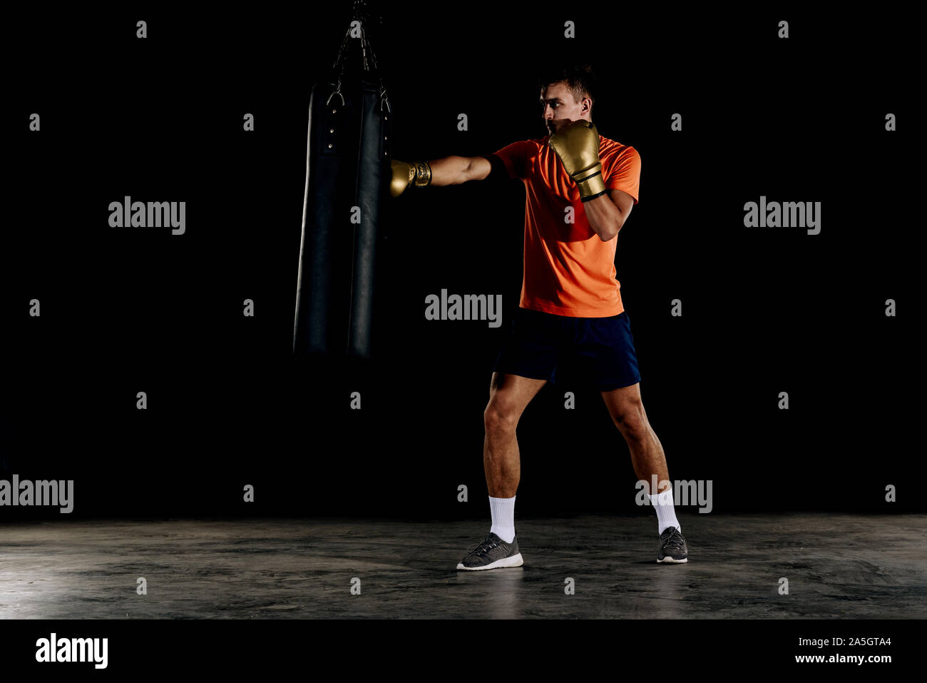 Silhouette männliche Boxer Schlagen eines riesigen Boxsack ein Boxing Studio. Mann Boxer harten Trainings Stockfoto