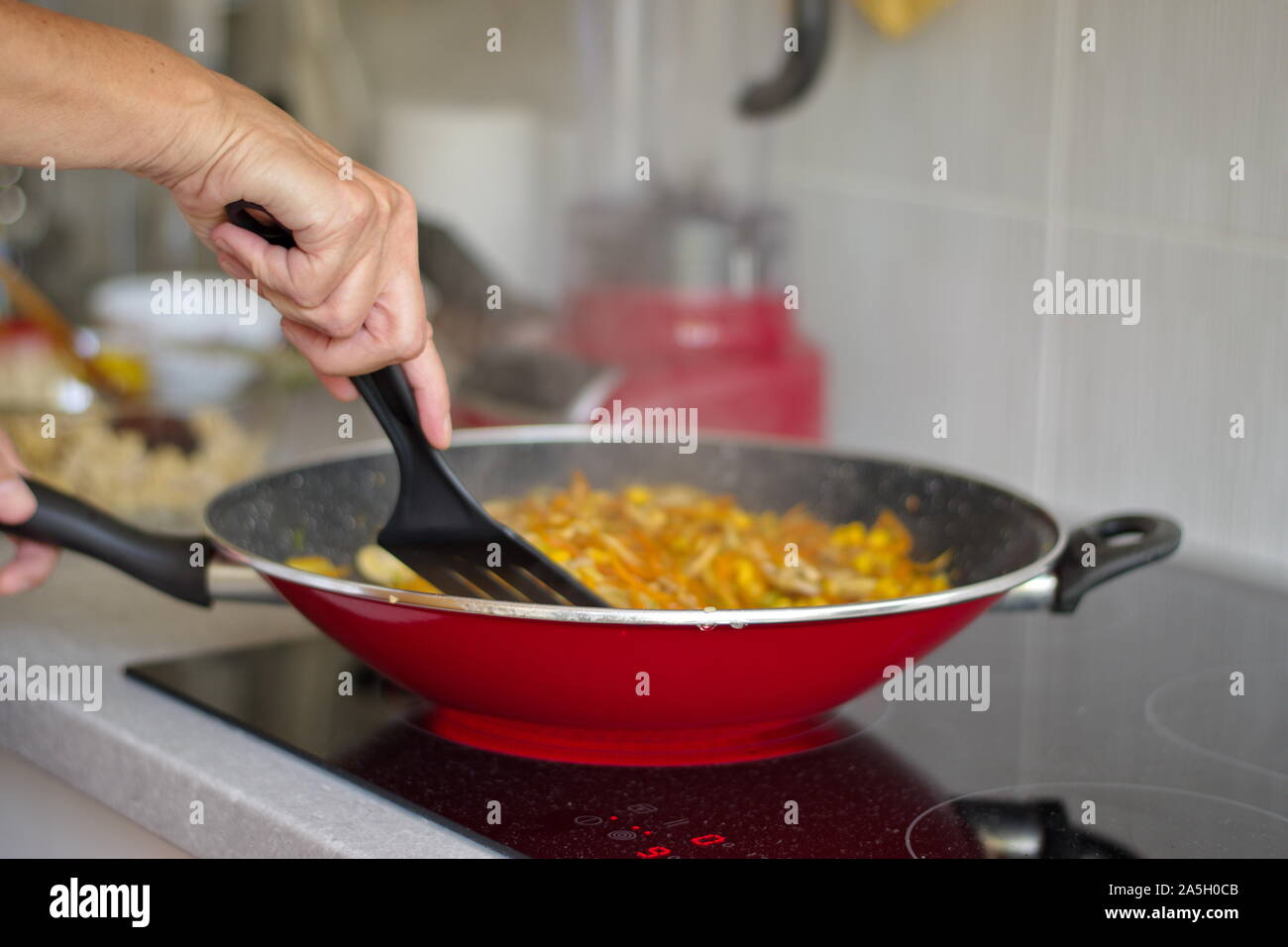 Mittelteil der Frau Kochen auf dem Herd Stockfoto