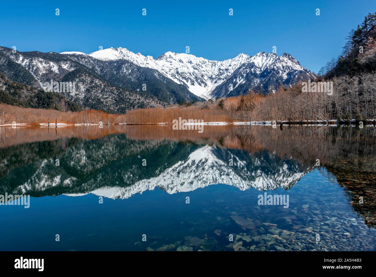 Die schneebedeckten Berge am See, Japanische Alpen spiegeln sich in Taisho Teich, schneebedeckten Berg Hotaka auf der Rückseite, Kamikochi, Matsumoto, Nagano, Japan Stockfoto