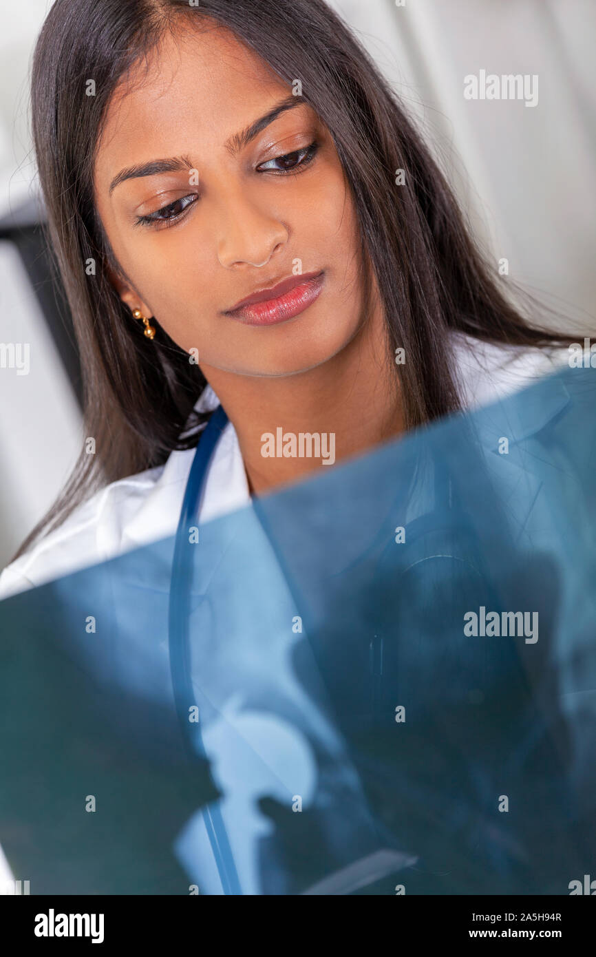Indische asiatische Frau Arzt in einem Krankenhaus mit Stethoskop Prüfung eines x-ray einer Hüftoperation Stockfoto