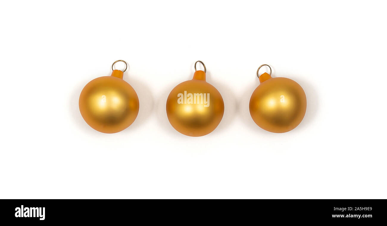 Weihnachtsdekoration Konzept. Drei kleine Weihnachten goldene Kugeln auf weißem Hintergrund. Stockfoto
