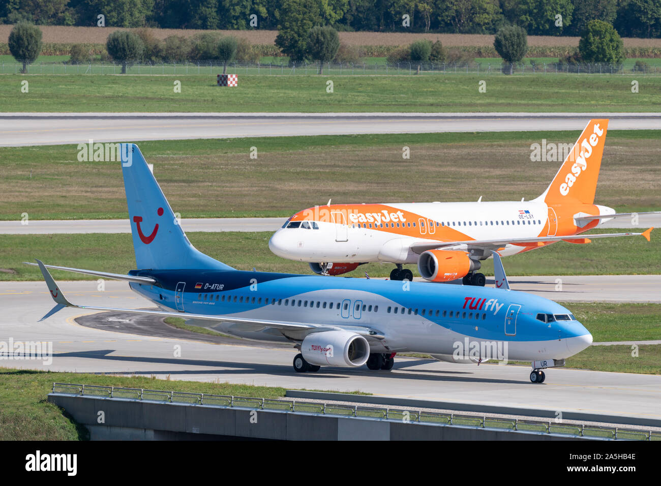 München, Deutschland - 18. September. 2019: TUIfly Boeing 737-800 D-ATUR und easyJet Europa Airbus A319-100 OE-LSY Rollen nach der Landung zum Terminal 1. Stockfoto