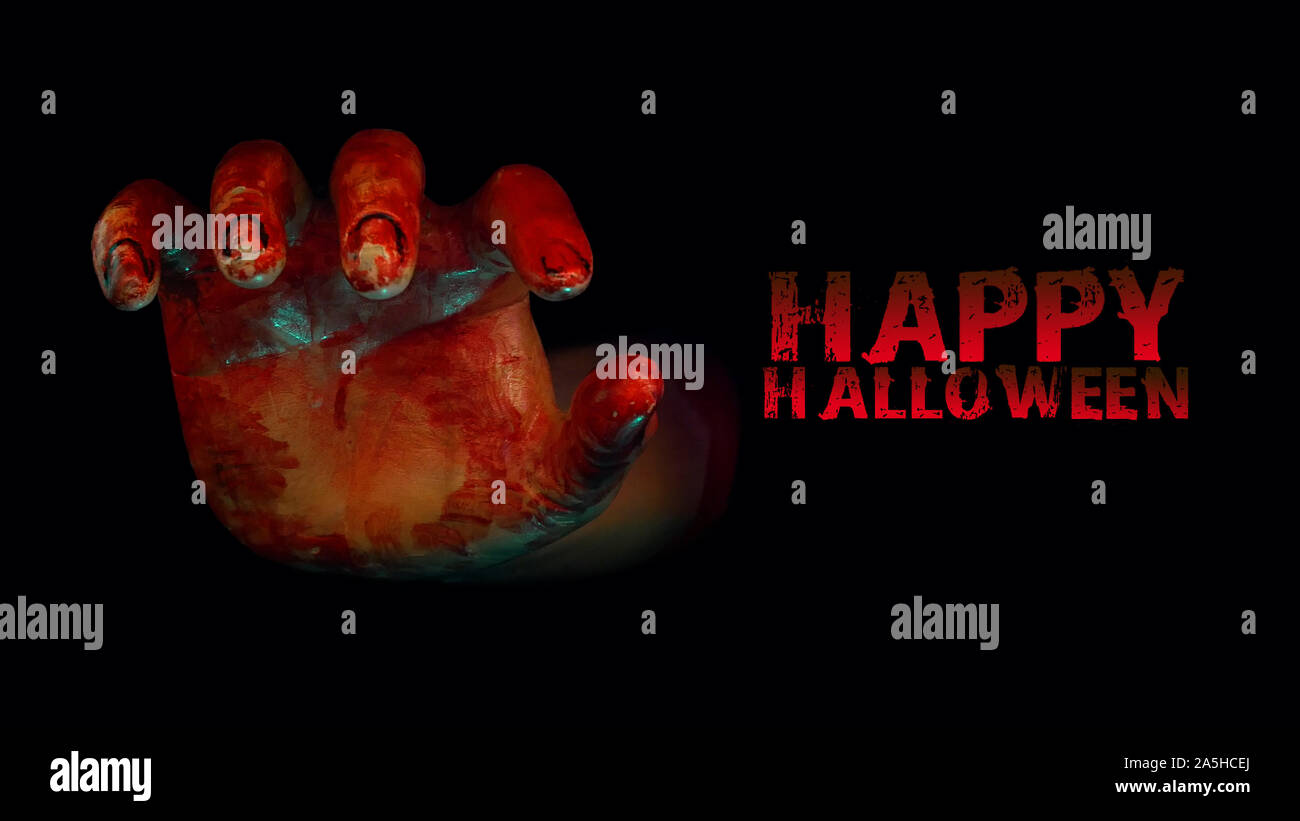 Blutige Hand erreichen Sie heraus aus dem dunklen Raum in Halloween haunted Nacht mit roter Farbe text Happy Halloween Stockfoto