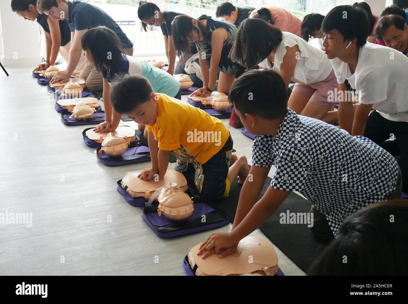 BANGKOK, THAILAND - 6. OKTOBER 2019: Ein Teil der Kinder und Erwachsenen, Teilnehmer der HLW Erste Hilfe Training Kurs mit Hilfe der Handpumpe auf der Brust von Dummy Stockfoto
