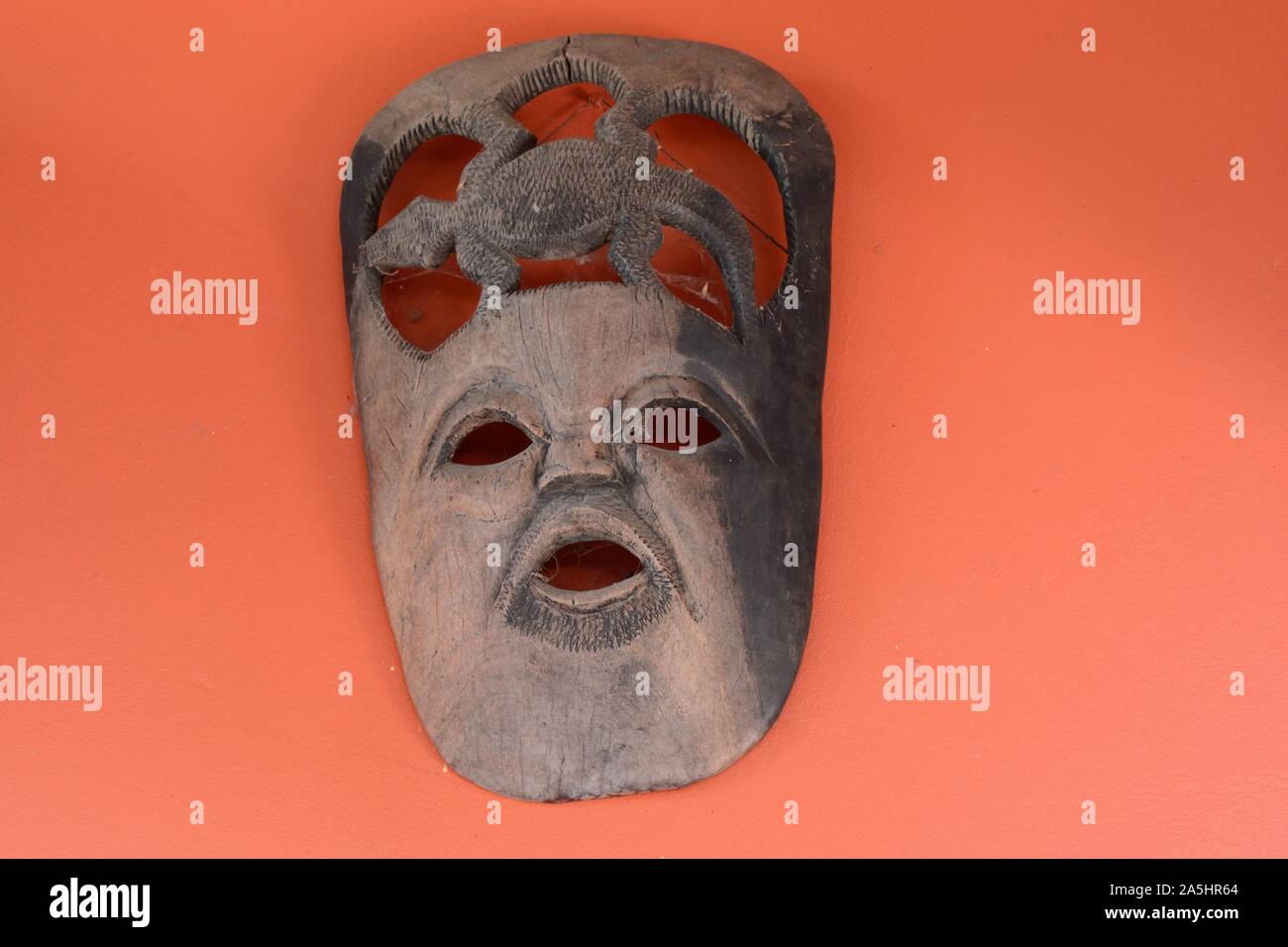 African tribal zeremoniellen Maske auf eine orange Wand sambischen Maske Stockfoto