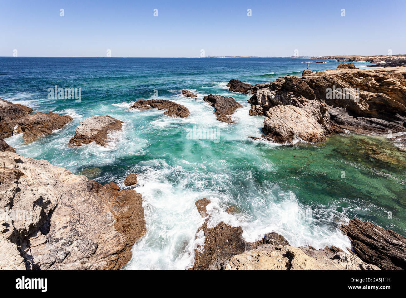 Transparente Cove von Wellen im Meer von Felsen in der Region Alentejo in Portugal geschützt. Stockfoto