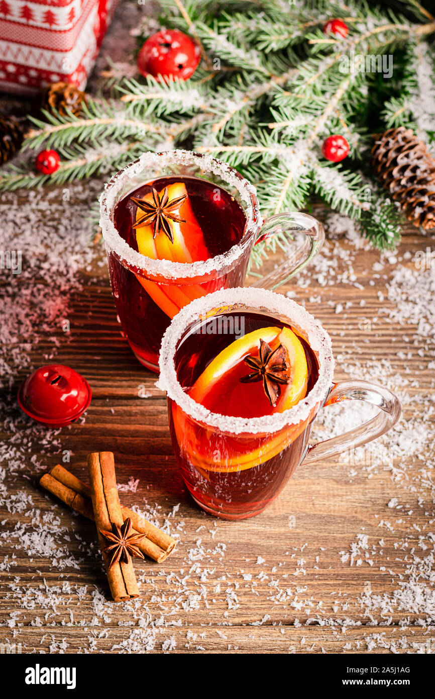 Zwei Gläser einen wärmenden Glühwein von einem traditionellen Getränk und Weihnachtsschmuck auf dem festlichen Tisch. Weihnachten Neujahr Konzept. Selektive Schwerpunkte Stockfoto