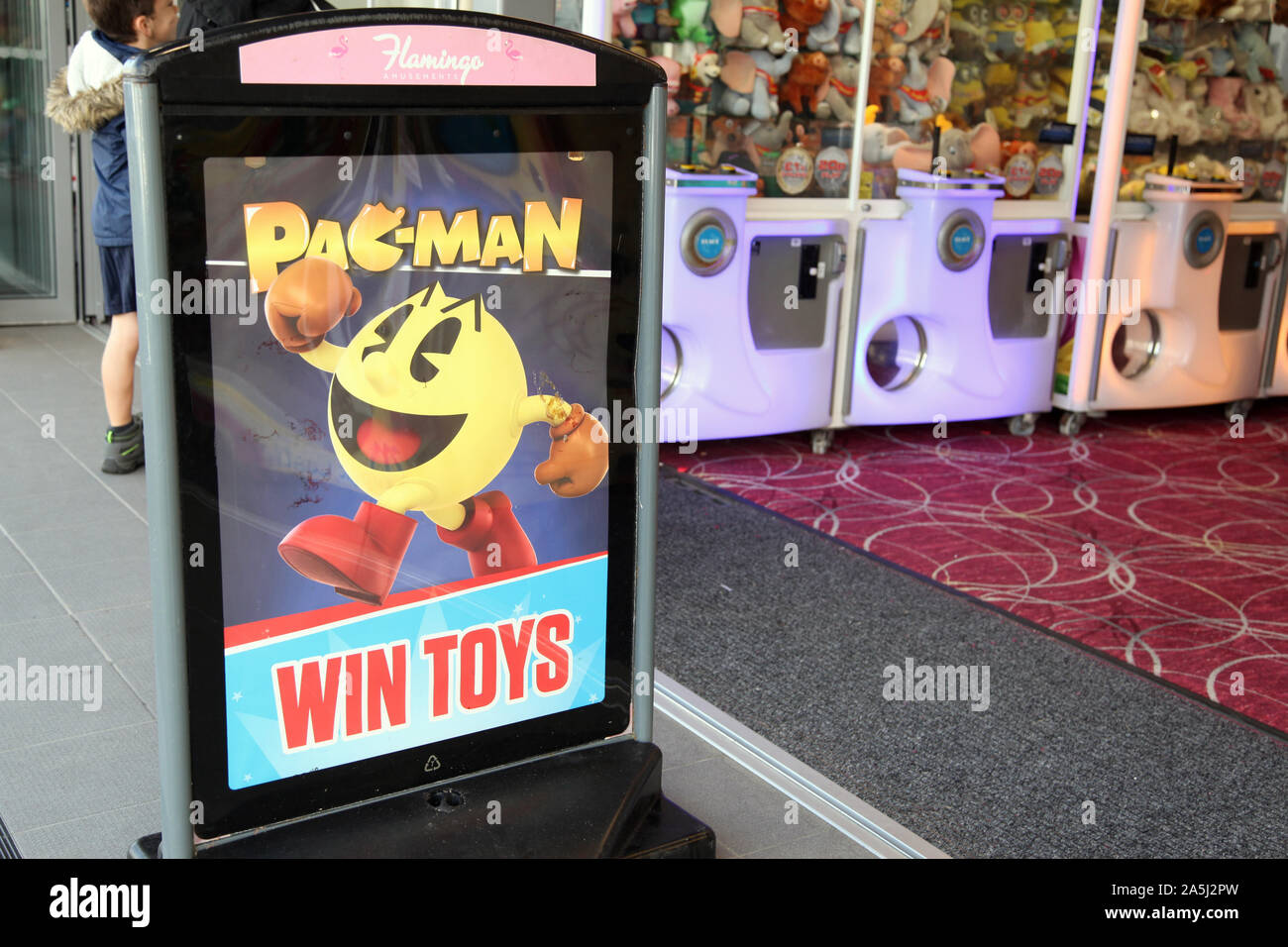 Pac Man Zeichen außerhalb arcade Vergnügungen, die die beliebte 8-bit Zeichen PacMan springen mit Faust in der Luft, 2019 Stockfoto