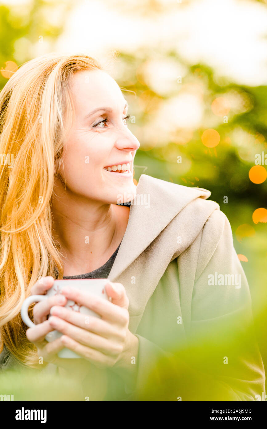 Glückliche Frau genießen Sie Weihnachten mit einer Tasse heißen Tee in der Hand. Stockfoto