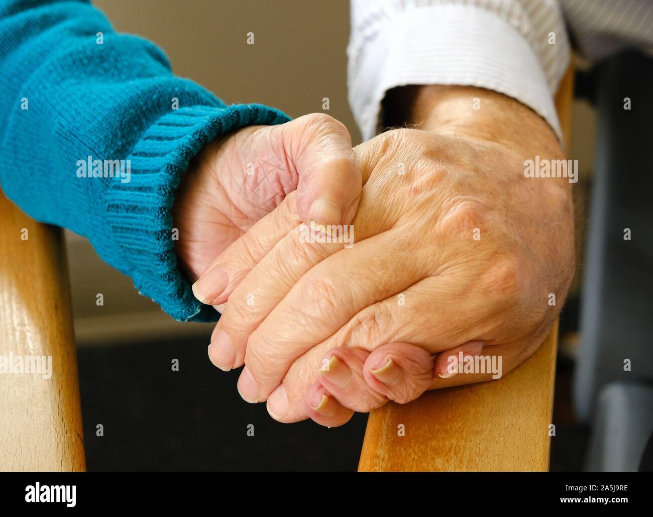 Alte Freunde (Mann und Frau) halten sich an den Händen in einem Pflegeheim Stockfoto