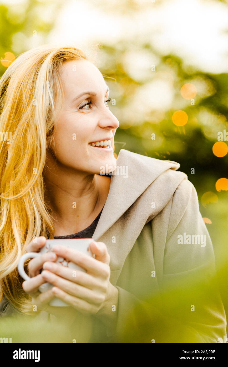 Glückliche Frau genießen Sie Weihnachten mit einer Tasse heißen Tee in der Hand. Stockfoto