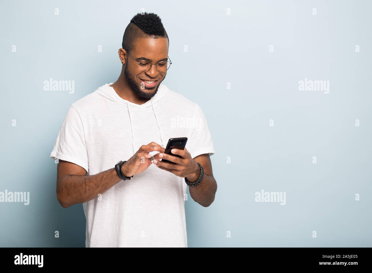 Happy biracial Mann surfen unbegrenzt Wireless Internet auf dem Smartphone Stockfoto