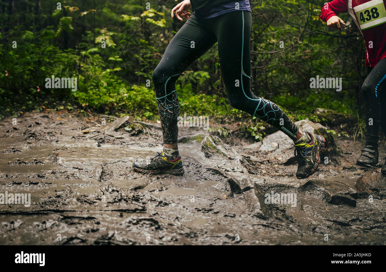 Schmutzige Füße Frau Läufer laufen Mountain Trail im Herbst durch Schlamm und Pfützen Stockfoto