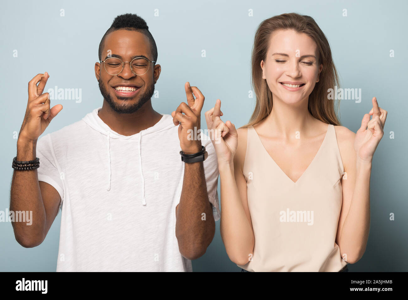 Abergläubische multiethnischen Paar kreuz Finger machen möchten Stockfoto