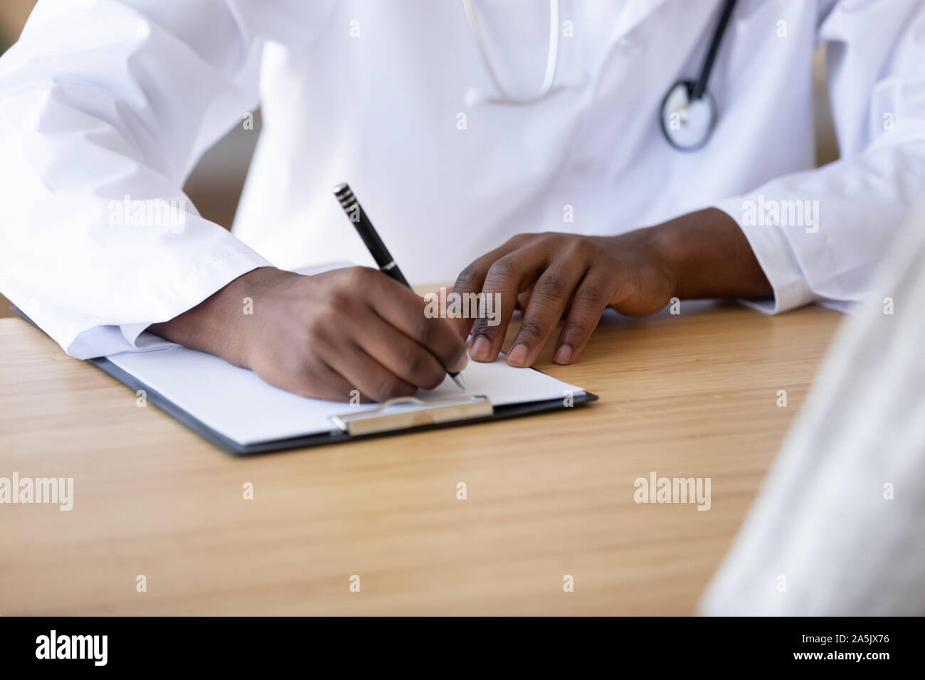 Nahaufnahme von Biracial Arzt schreiben Rezept in medical card Stockfoto