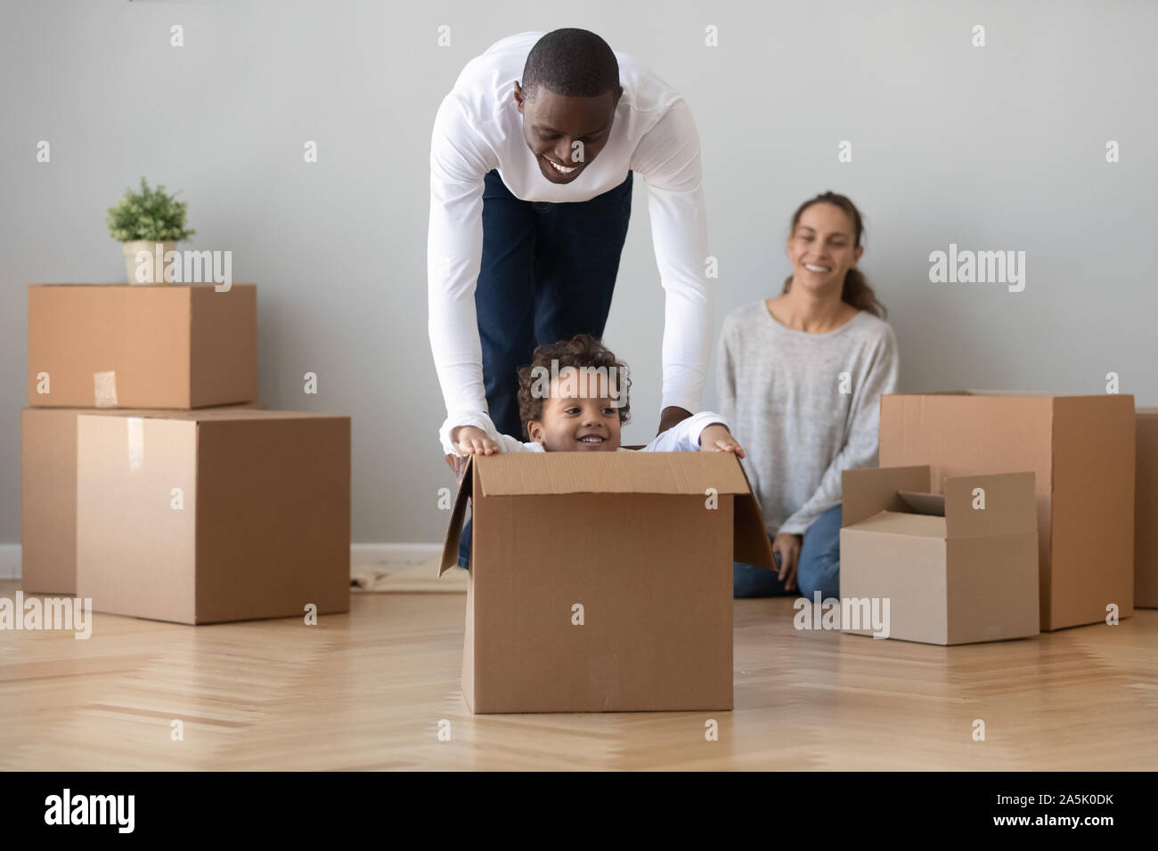 Happy African American Dad spielen mit Sohn am Umzugstag Stockfoto Happy African American Dad spielen mit Sohn am Umzugstag Stockfoto