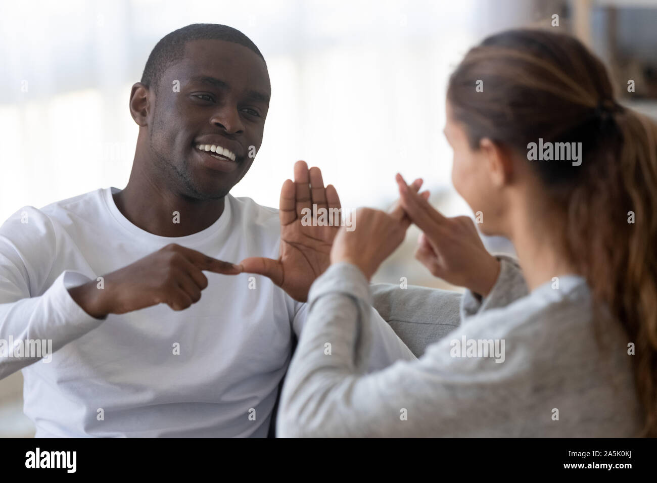 Lächelnd multirassischen Freunden sprechen mit Zeichensprache Stockfoto