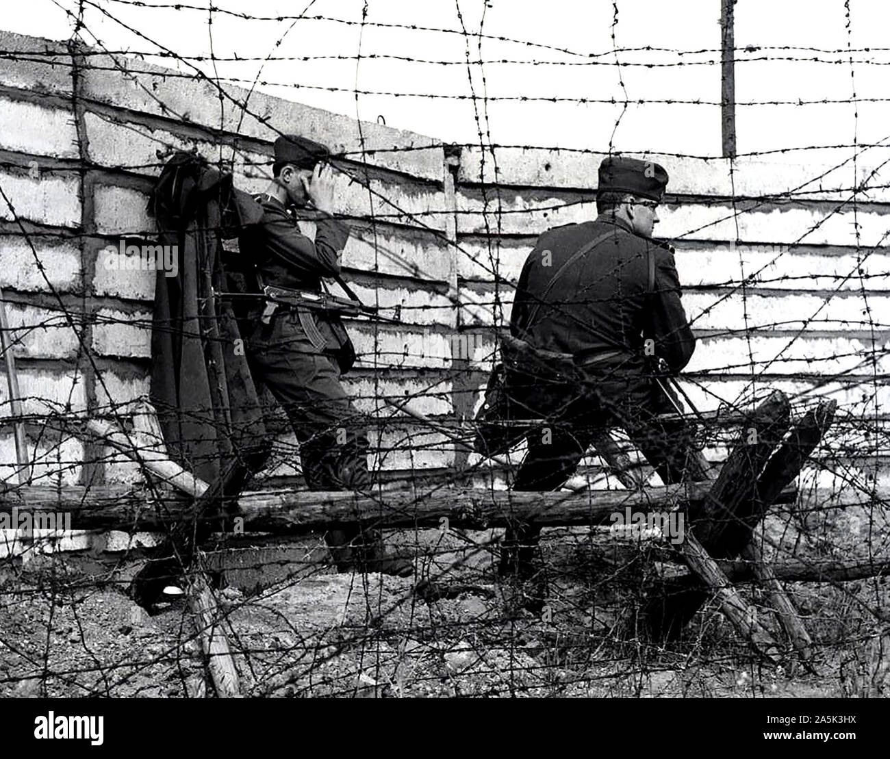 Ostdeutsche Soldaten vor der größten Mauer gebaut bis jetzt - die Arbeit Mannschaften errichtet fünf Meter hinter der alten, baufälligen und teilweise eingestürzten Wand, eine betonplatte neue, stabile Wand von einem Meter Breite, mit Zement ausgegossen. Es hat die Höhe von 2,50 Meter und ist damit die höchste Wand, die es gibt. 10/10/1962 Stockfoto