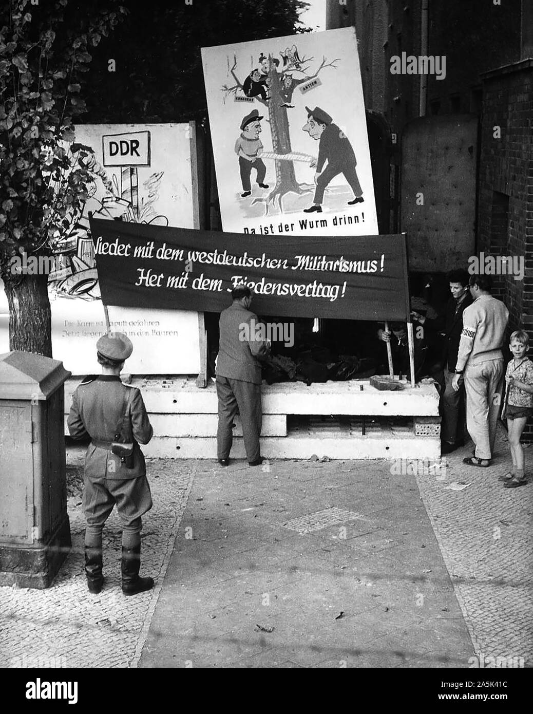 9/21/1961 - Banner sagt: "Weg mit Westdeutschen Militarismus! Geben Sie uns einen Friedensvertrag!" Die Bewohner des Ostens Berlin Häuser, die in der Nähe von der Grenze an der Wand werden evakuiert Stockfoto