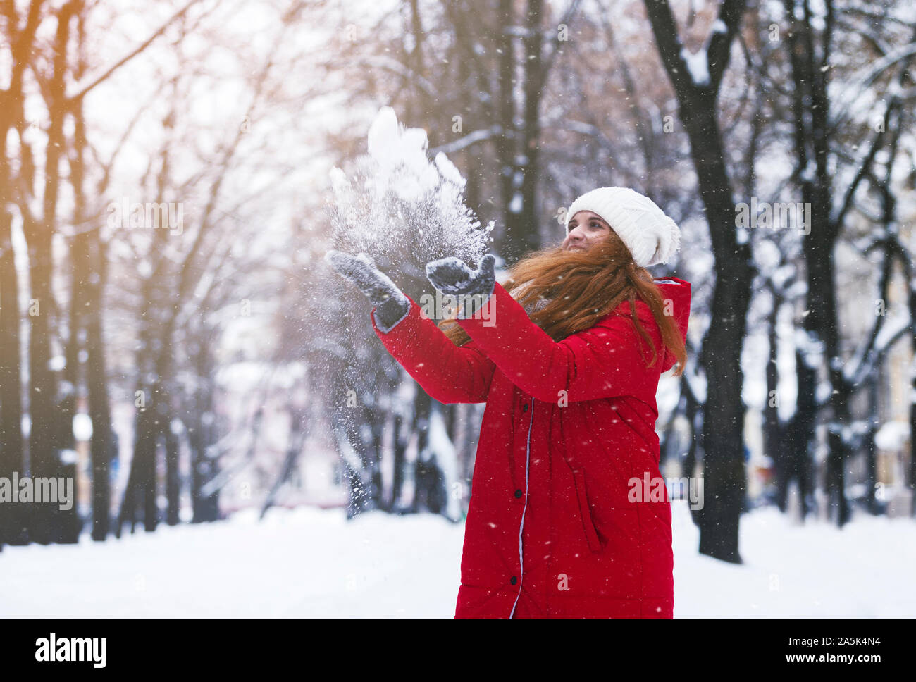 Positive attraktives Mädchen werfen Schnee in der Luft Stockfoto