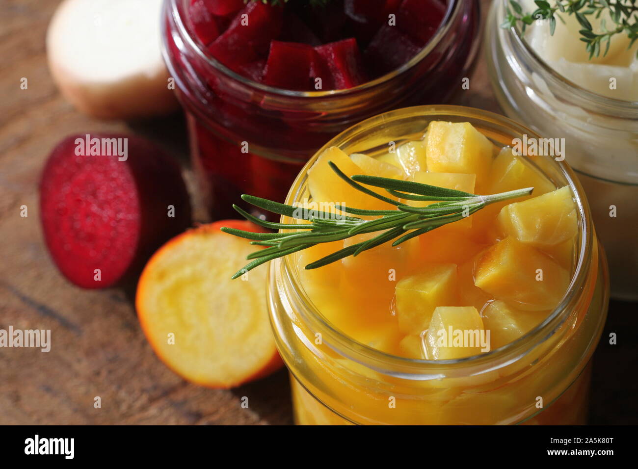 Eingelegtes rot, weiss, orange Zuckerrüben in Gläsern. Vielzahl Pickles auf rustikalen Hintergrund Stockfoto