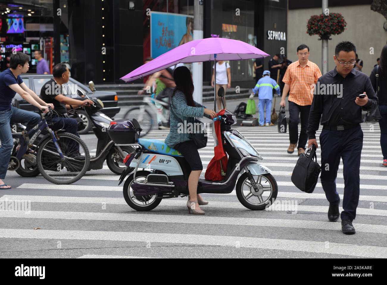 China Shanghai Frau auf dem Motorrad mit Schirm Stockfoto